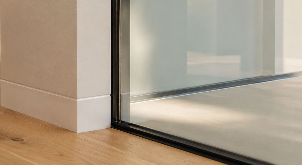 Detail of frosted glass meeting a slim black window frame