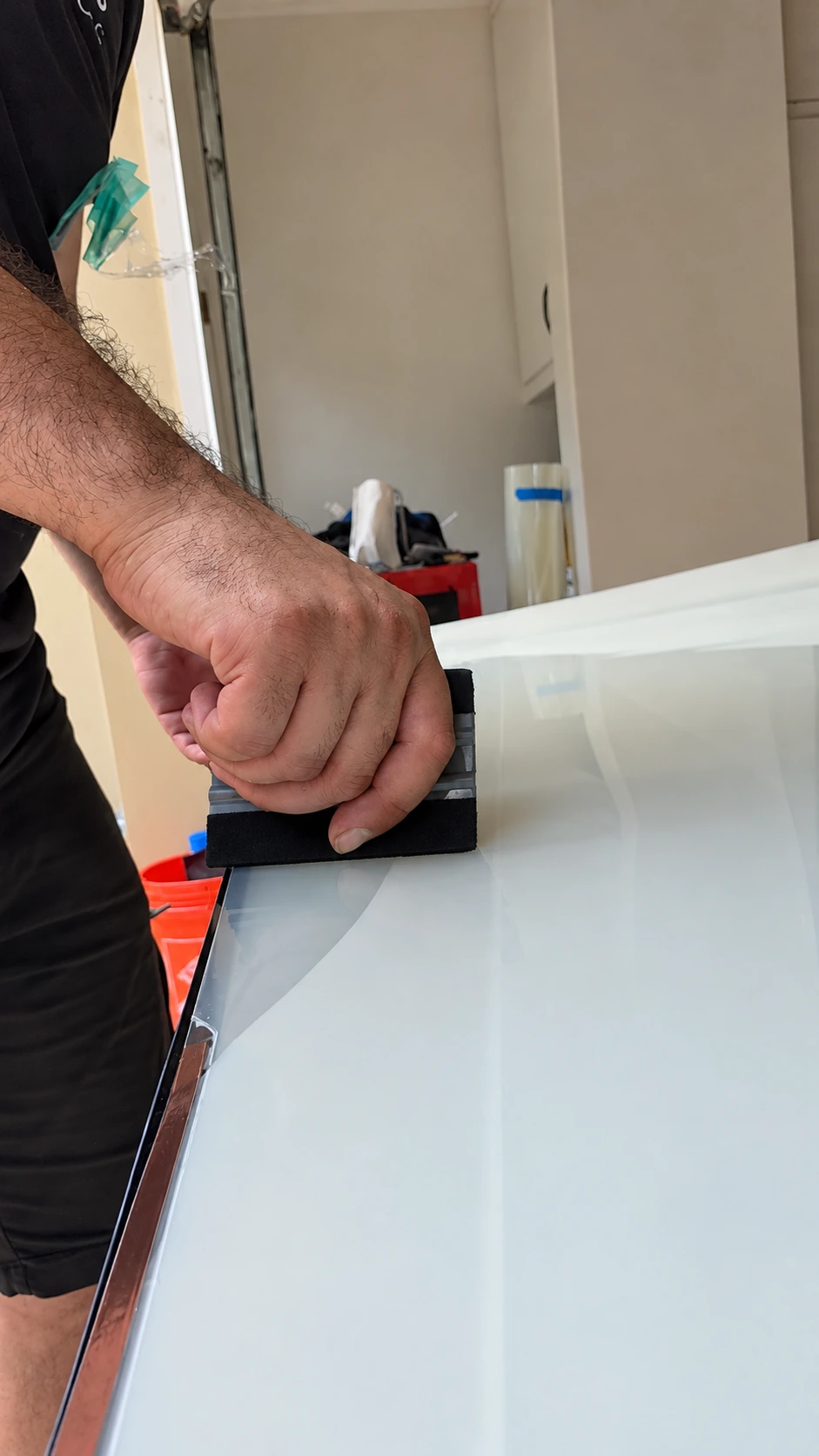 An installer gradually applying PDLC film across the glass with a squeegee